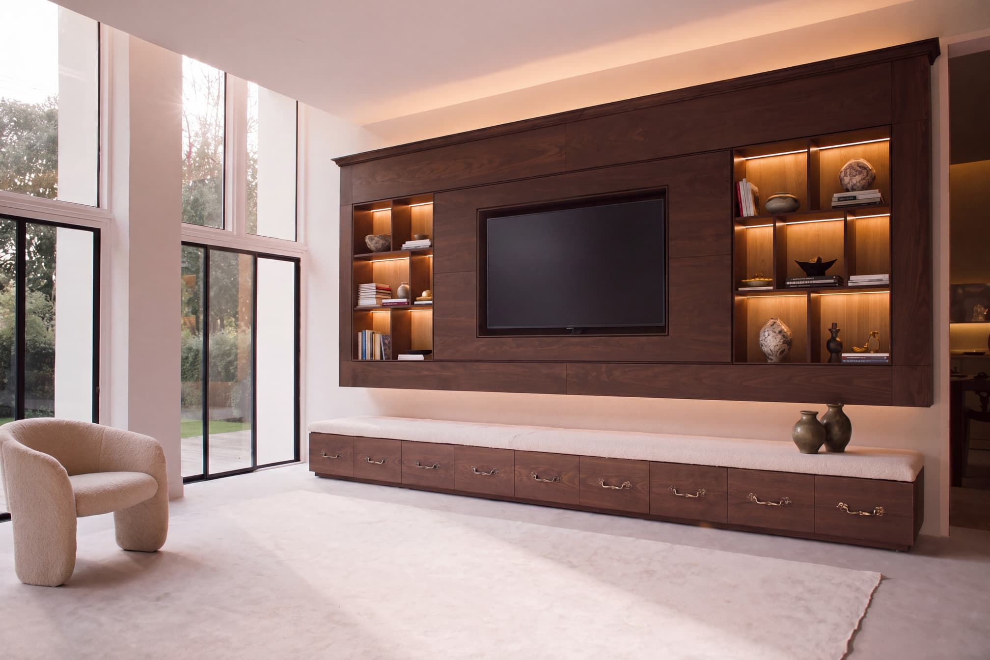 A fitted media wall in an open-plan living space with integrated shelving and cabinetry