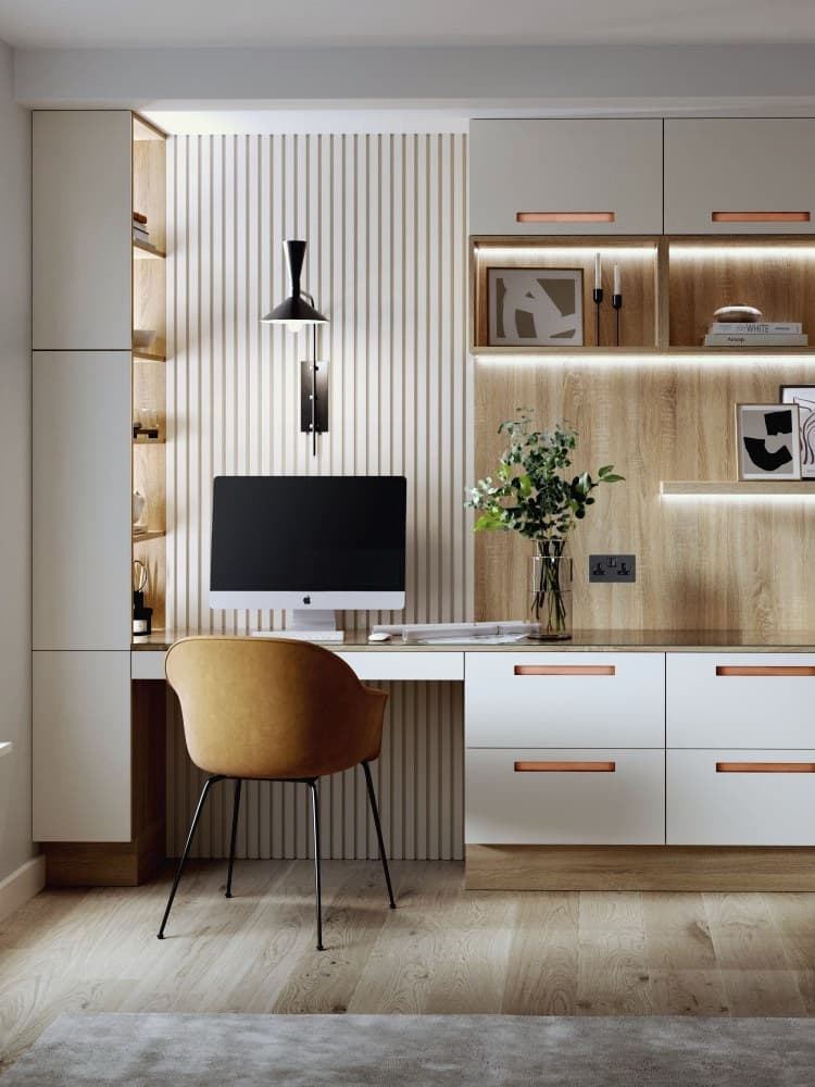 A fitted desk bay in graphite grey with a warm oak-lined back panel lit by a concealed LED strip, an oak worktop and a tall oak shelving column